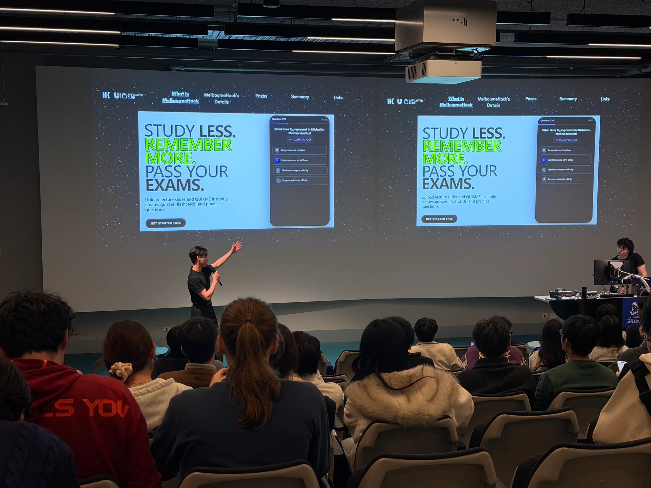 QUIXME being presented on stage to a full lecture theatre at Melbourne Hack 2026